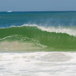 Endless golden sand shoreline and crashing Atlantic waves along the Nigerian coast