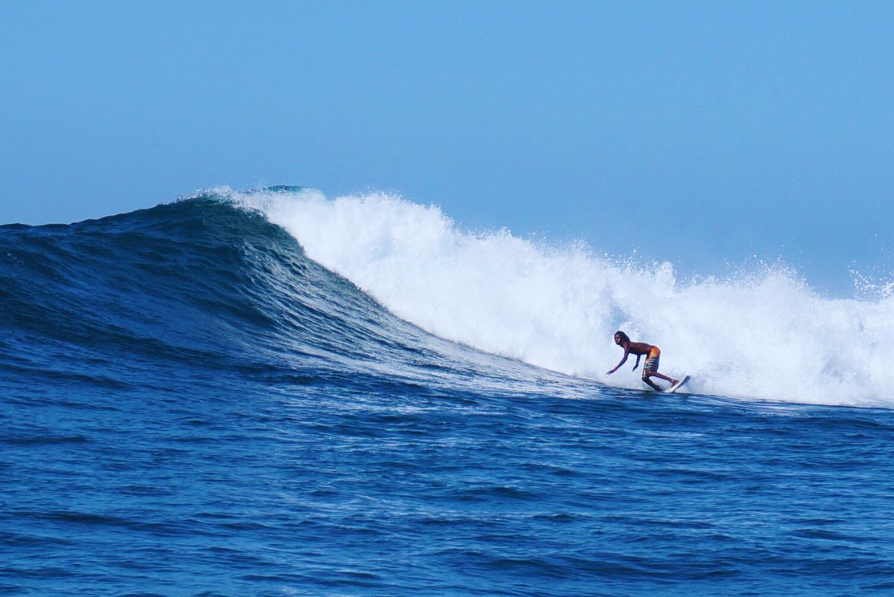 Surfer catching an Atlantic ocean wave along the Senegalese coast