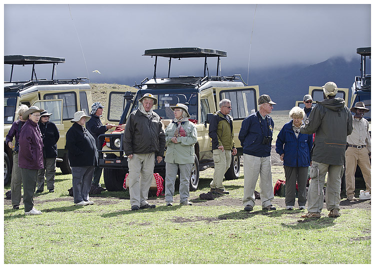 Safari traveler wearing neutral khaki and stone clothing with wide-brim hat during an early morning game drive.